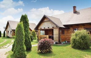 Una fila de cabañas de madera con un camino pavimentado y arbustos bien cuidados.