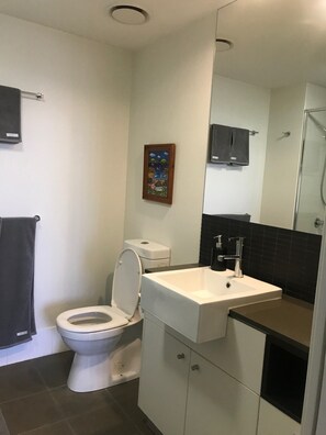 Combined shower/tub, hair dryer, towels, soap - The Lyne Suite @ Curtis Apartments (Gladstone Central)
