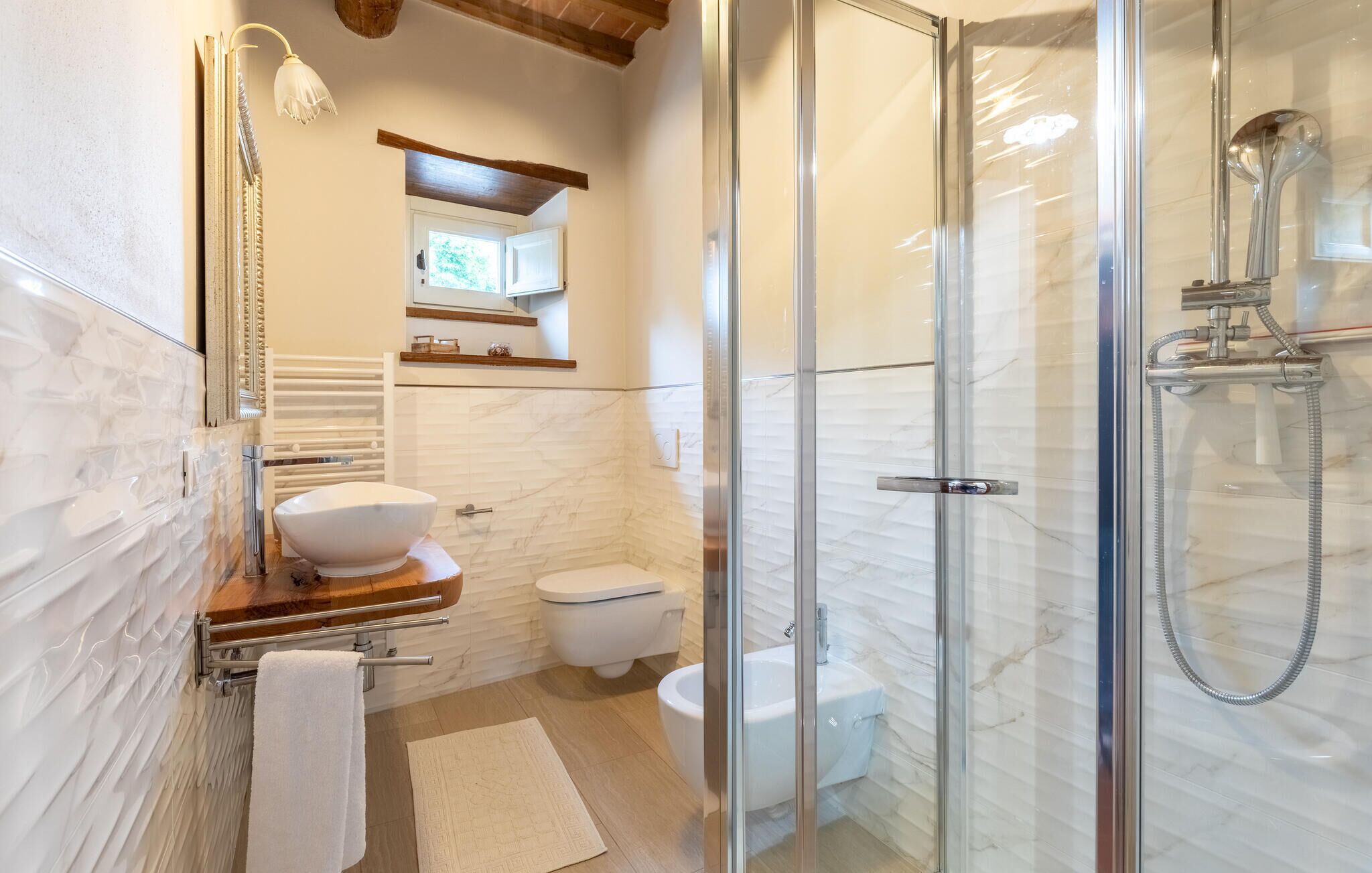 A modern bathroom with a glass-enclosed shower, a white toilet, and a vanity with a bowl sink.