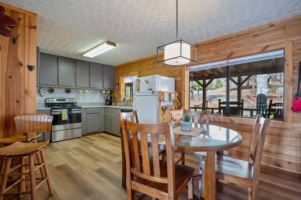 Un interior de madera con cocina, comedor y ventanas amplias.