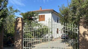 A gated entrance to a house with a brick wall and a metal gate. - Apartment Sonia by Interhome (Riparbella)