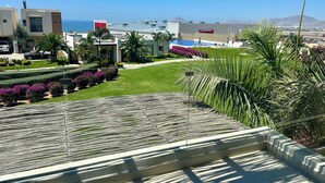 Un complexe hôtelier doté d’une piscine, de palmiers et offrant une vue sur l’océan.