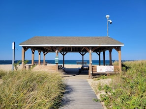 Un pavillon de plage doté d’un toit en bois et d’un banc.