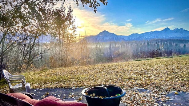 Cómodo espacio al aire libre con una silla y un brasero, con vistas a un paisaje montañoso.