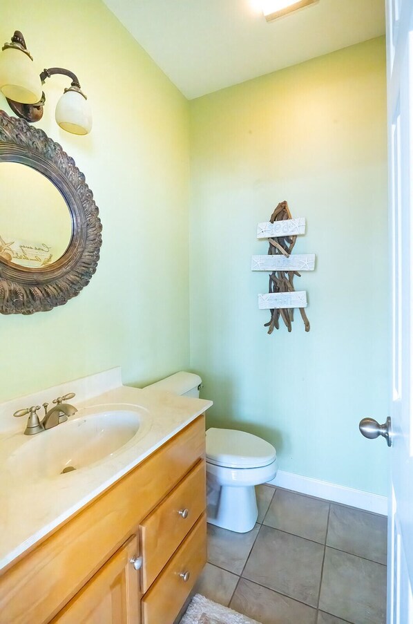 Un bagno con lavabo, specchio, servizi igienici e mobile contenitore.