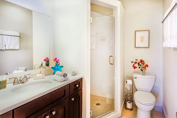 A bathroom with a shower, toilet, and sink. - Paradise Point Ocean and Pool View 2 king beds (Wheeland Settlement)
