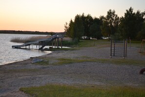 A beach with a metal slide and a playground structure. - Holiday apartment - the Peene Valley (Bentzin)