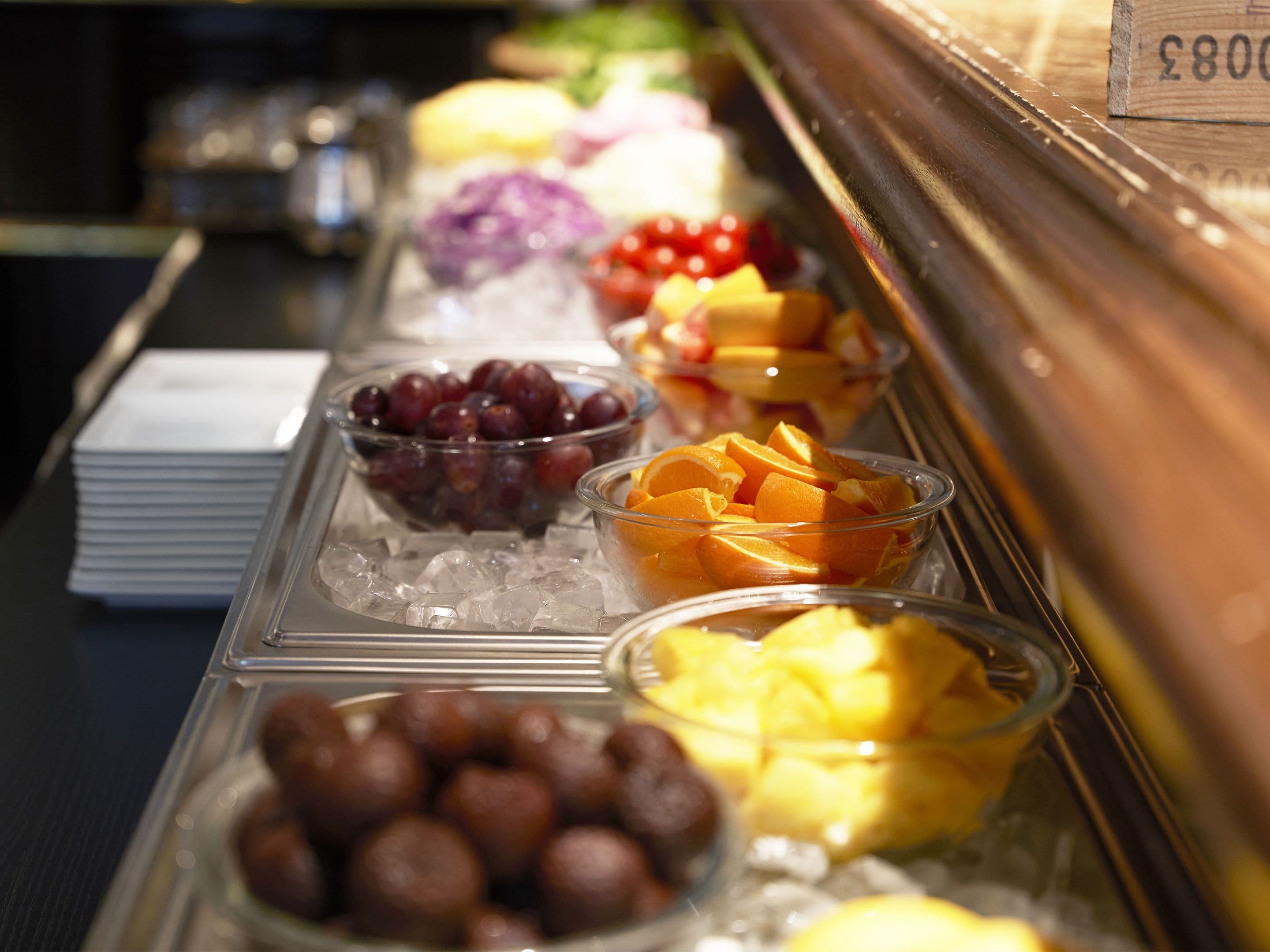 Buffet com diversas frutas e sobremesas.