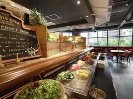 Un restaurante con carta de cervezas artesanales, barra de ensaladas y zona de estar con mesas y sillas.