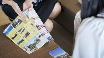 A person holding a brochure with various images and text, likely a travel guide or informational pamphlet.