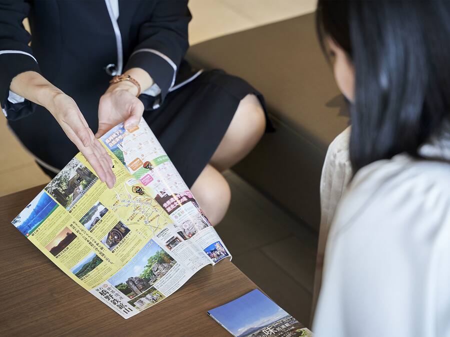 A person holding a brochure with various images and text, likely a travel guide or informational pamphlet.