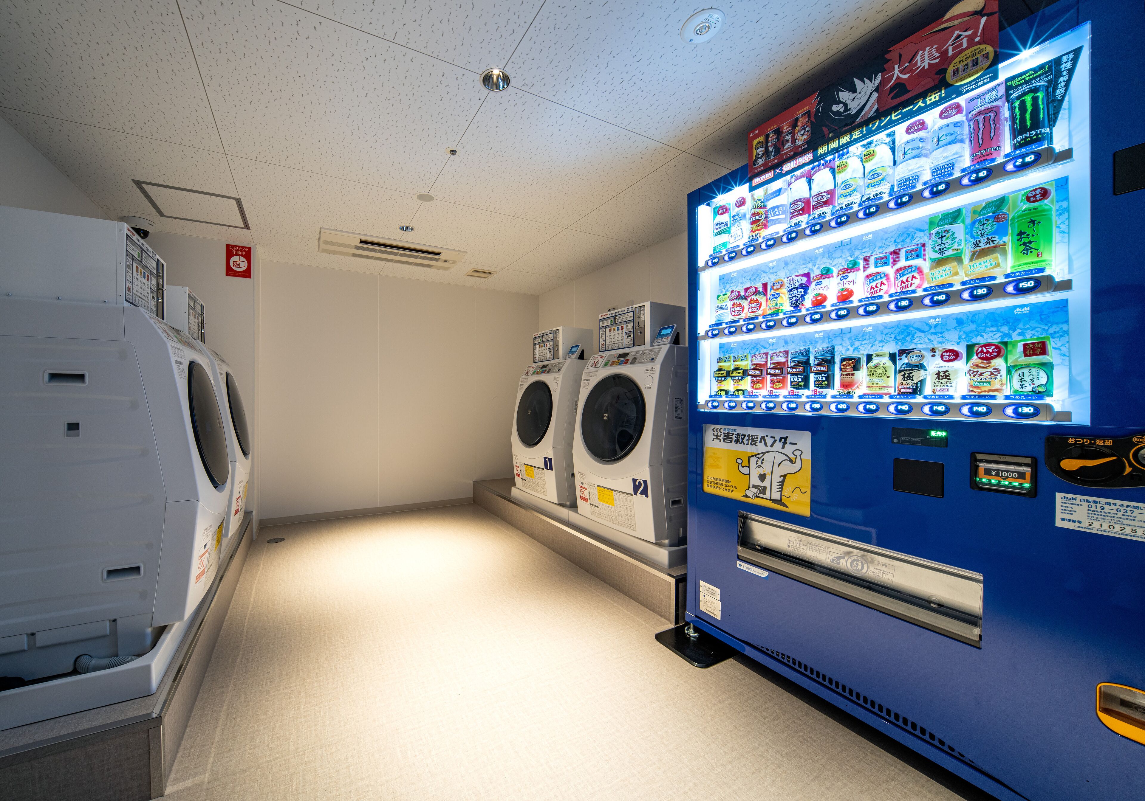 A laundry facility with multiple washing machines and a vending machine.