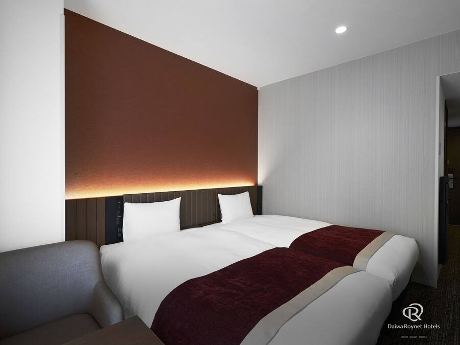 Een moderne hotelkamer met een groot bed, een nachtkastje en een stoel.
