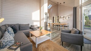 A modern living room with a sofa, coffee table, and dining area. - Nice home in Krems II/Warderbrück with sauna (Krems II/Warderbrück)