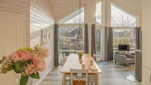 A spacious room with a large dining table, chairs, a TV, and a cozy seating area with a sofa and armchairs. - Nice home in Krems II/Warderbrück with sauna (Krems II/Warderbrück)