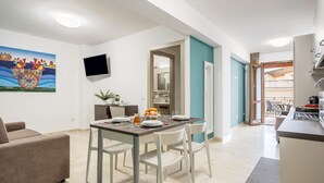 Une cuisine moderne dotée d’une cuisinière intégrée et d’un coin repas avec une table mise pour deux personnes.