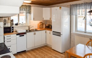 A compact kitchen with white cabinets, a built-in oven, and a refrigerator.