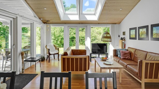 Un salon spacieux avec un haut plafond, de grandes fenêtres et un coin salon confortable.
