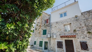 Un bâtiment en pierre doté d’un balcon, d’une porte et d’une fenêtre.