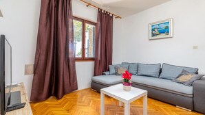 Un soggiorno moderno con un divano grigio, un tavolino bianco e un quadro appeso al muro.