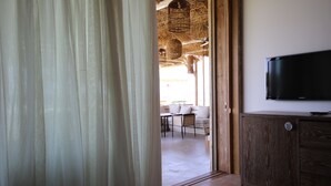 A room with a wooden cabinet and a flat-screen TV. - LOST AT SEA (Damour)