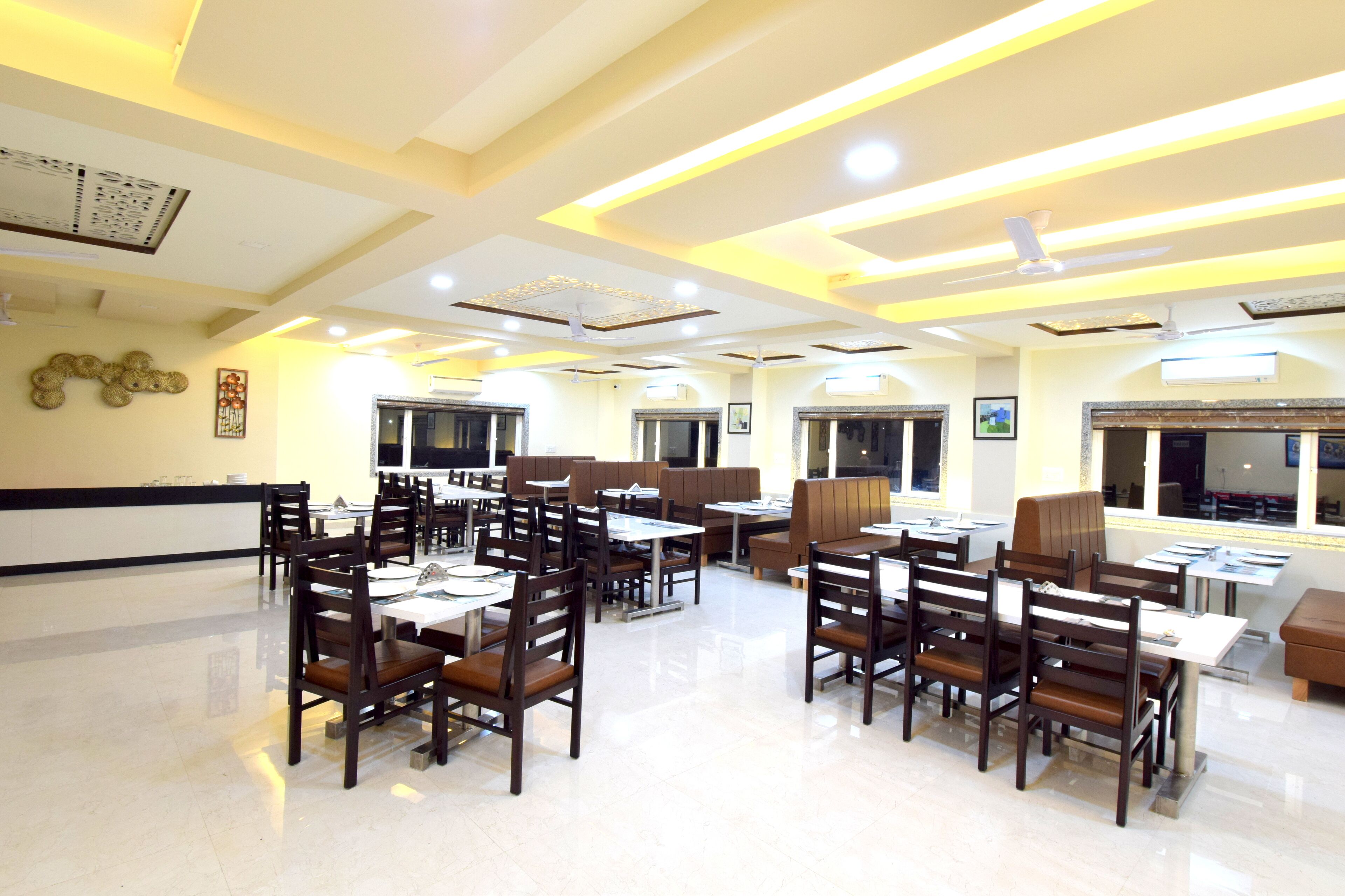 A spacious restaurant with high ceilings, modern lighting, and a clean, polished floor.