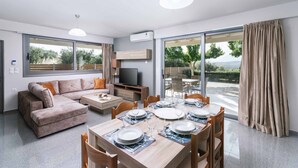 A modern living room with a sofa, coffee table, and dining area set for six.