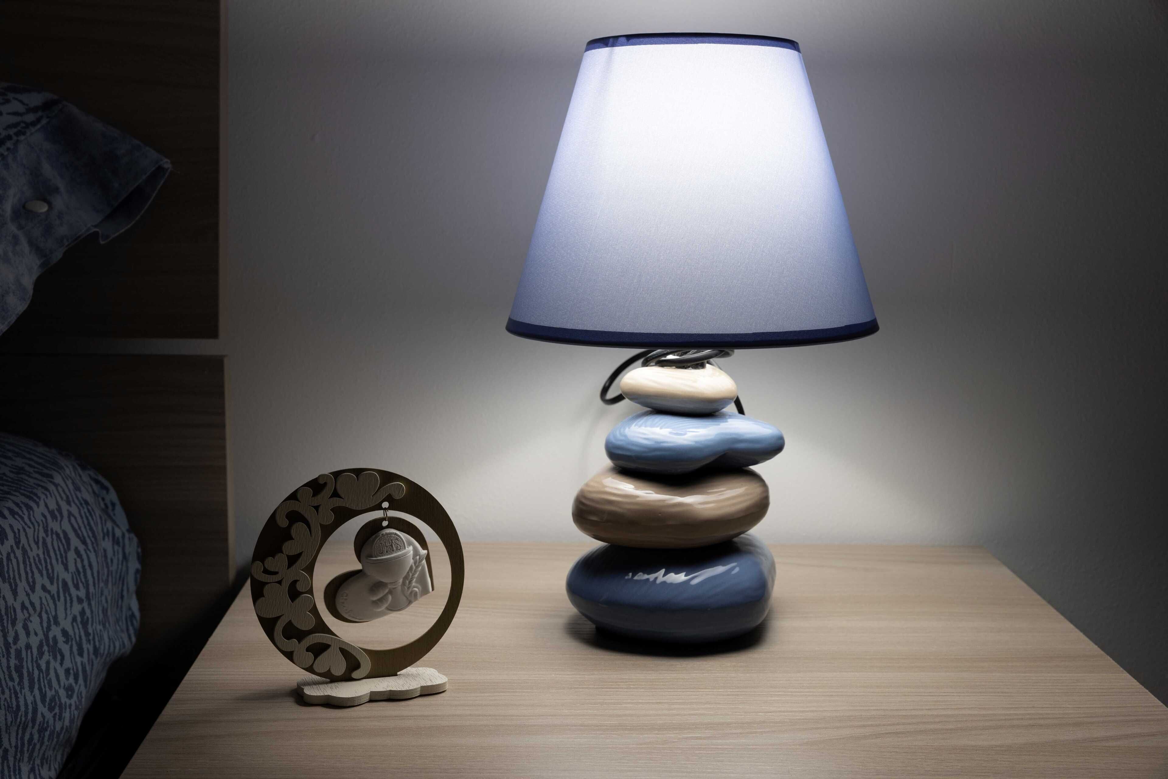 A bedside table with a lamp and a decorative plate.