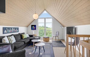 Relax in this stylish living space with a large sofa, coffee table, and chairs, offering a view of the outdoors.