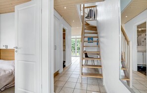 Staircase leads to a bedroom with a bed and nightstand.