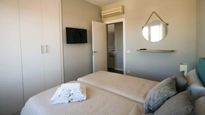 A bedroom with a bed, a wardrobe, a television, and a mirror. - Gran Vía Terrace w/ Royal Palace Views, Central (Madrid)