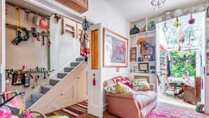 Un salon chaleureux avec un escalier, un canapé et un coin repas.