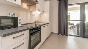 A modern kitchen with a built-in oven, microwave, and a large window with a view of the outdoors. - Cozy apartment in Sukosan with WiFi (Sukosan)