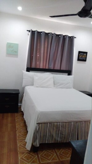 A hotel room with a bed, a nightstand, a wall-mounted sign, and a ceiling fan. - Hotel Casa Docia Samana - Standard Double Room - 4 (Samaná)