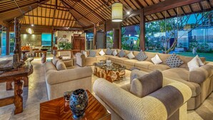 A spacious living area with a high ceiling and large windows, furnished with sofas and a coffee table. - In 1 word: WOW! Unique, Breathtaking and Luxury! (Candidasa)