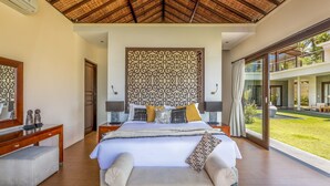 A spacious bedroom with a large bed, a wooden desk, and a view of the outdoor garden. - In 1 word: WOW! Unique, Breathtaking and Luxury! (Candidasa)
