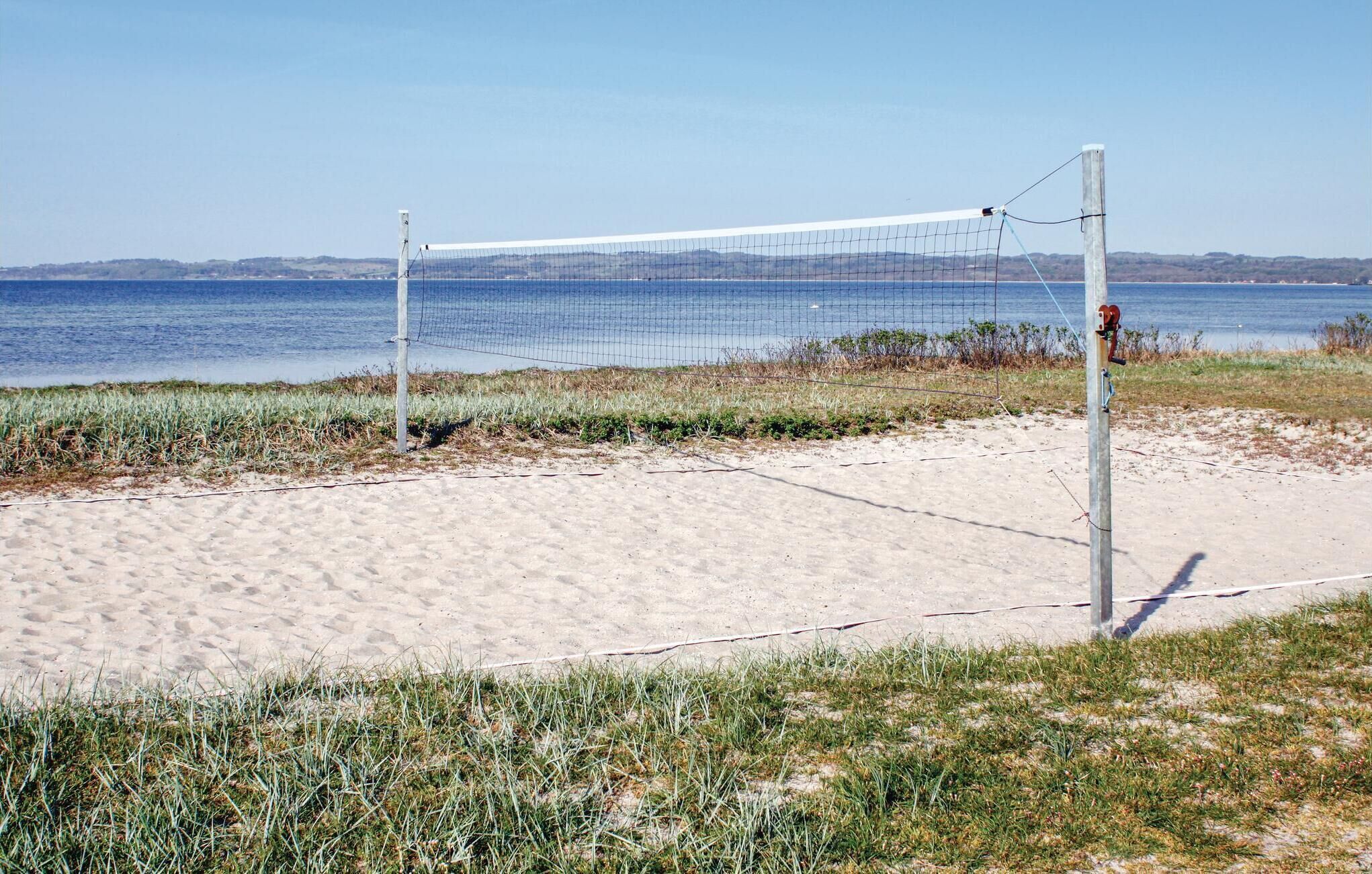 A beach volleyball net with a view of the sea in the background.