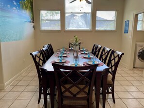 A dining area with a long table set for six, surrounded by wooden chairs. - GaMe RoOm, Sleep 12, Colorful Back Yard, Beach(A) (Long Beach)