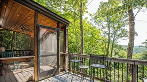 A wooden deck with a glass door leading to a room, surrounded by trees. - Moonlight Ridge*Sleeps 8*PetsoK*VIEW*Resort Access (Deep Gap)