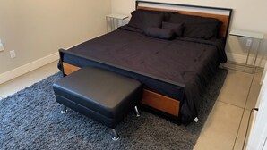 Ein ordentlich eingerichtetes Schlafzimmer mit Bett, Nachttisch und Bank.