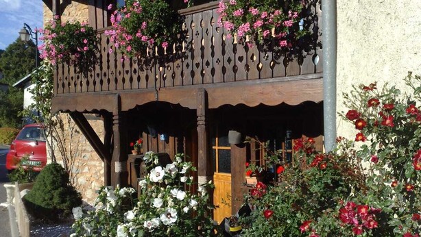 En træbygning med en balkon pyntet med blomster.