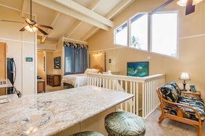 Cozy retreat with a comfortable seating area, large window, and a bed with a canopy.