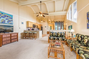 Relax in this open living area with a large TV, comfortable sofa, and kitchenette.