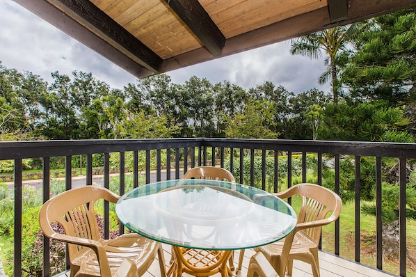 Relax in this serene outdoor seating area, surrounded by lush greenery and trees.