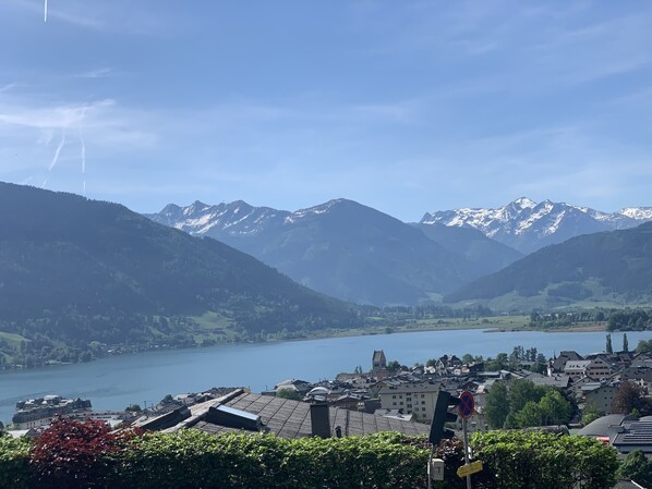 Un pueblo con un lago, montañas y cielo despejado.