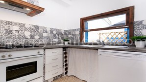 A kitchen with a gas stove, oven, and dishwasher, a window, and patterned backsplash tiles. - 3 bedrooms ground floor, large terrace and pool, near the beach. (Can Picafort)