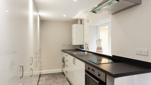 A modern kitchen with a built-in oven, a sink, and a window. - 4 bedroom accommodation in Market, Clarence & Sandquay (Market, Clarence & Sandquay)