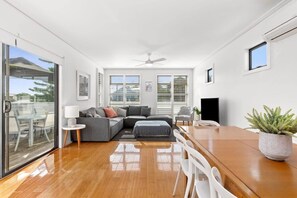 Un salon moderne avec un canapé, une table à manger et un ventilateur de plafond.