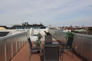 Une terrasse sur le toit, avec des sièges en plein air et une vue sur le paysage urbain.