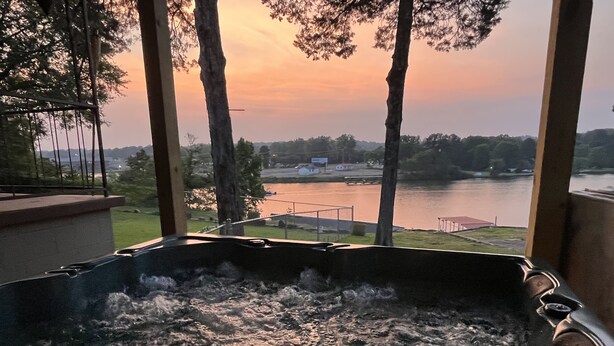 A hot tub with a view of a river and trees.